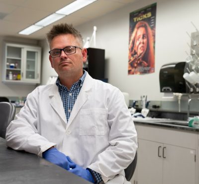 person posing in lab, wearing lab coat