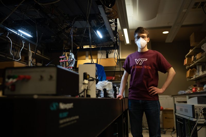 A male student standing in a physics lab