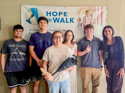 Lacey Ngo and fellow Hope to Walk volunteers with a prosthetic they built